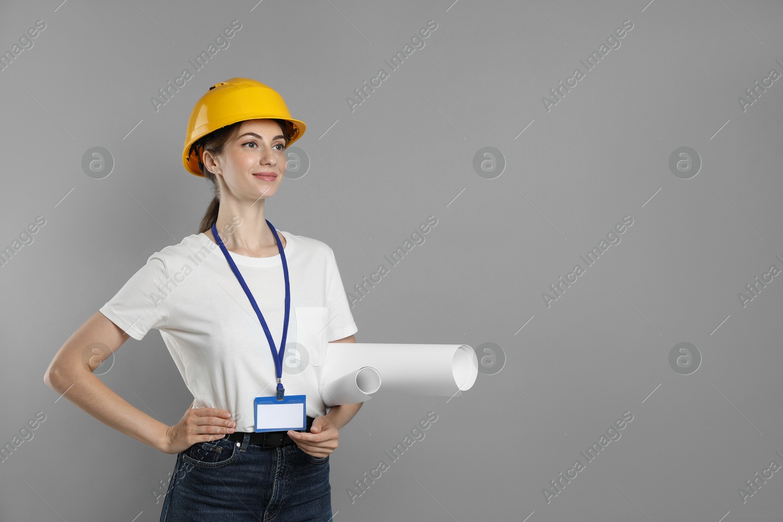 Photo of Engineer in hard hat with drafts on grey background, space for text