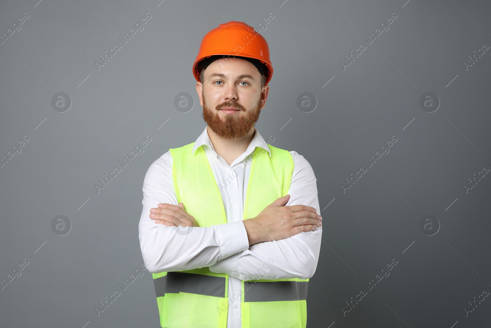 Photo of Engineer in hard hat on grey background