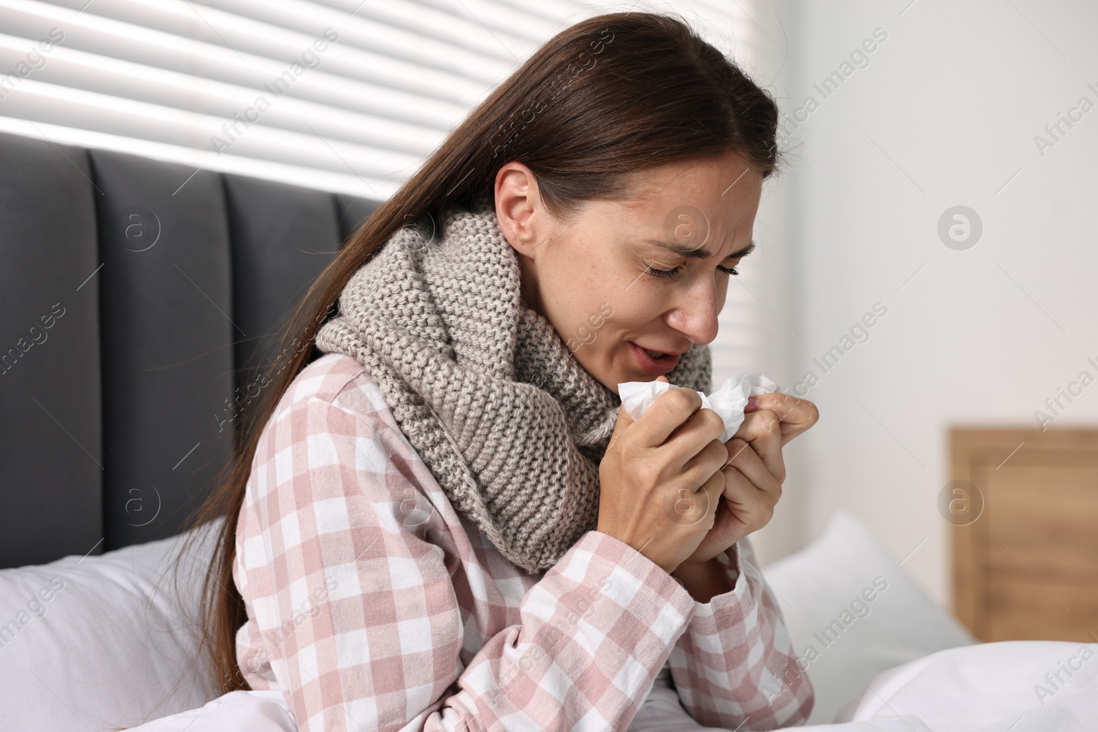 Photo of Sick woman with tissue in bed. Cold symptoms