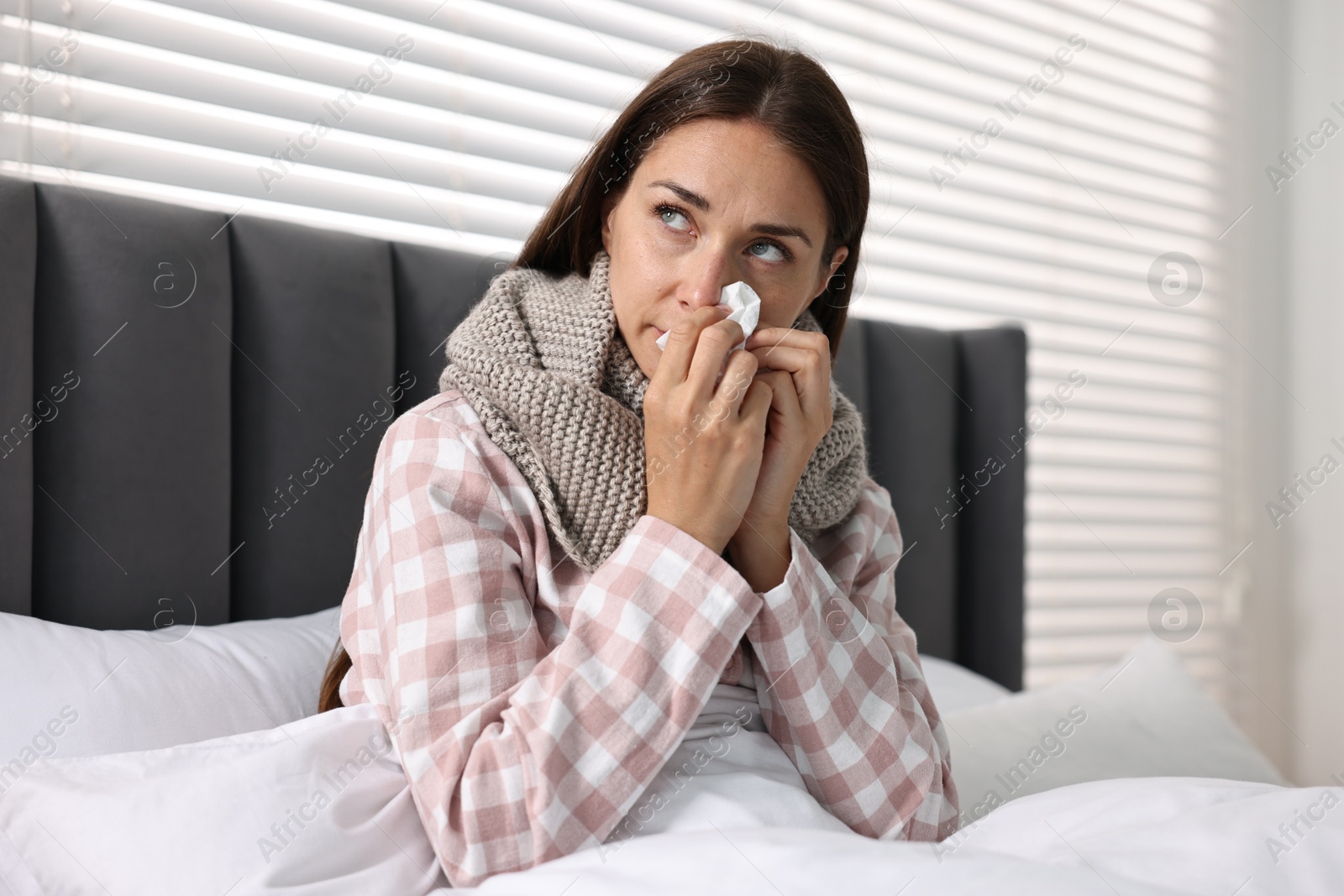 Photo of Sick woman with tissue in bed. Cold symptoms