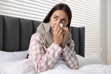 Photo of Sick woman with tissue in bed. Cold symptoms