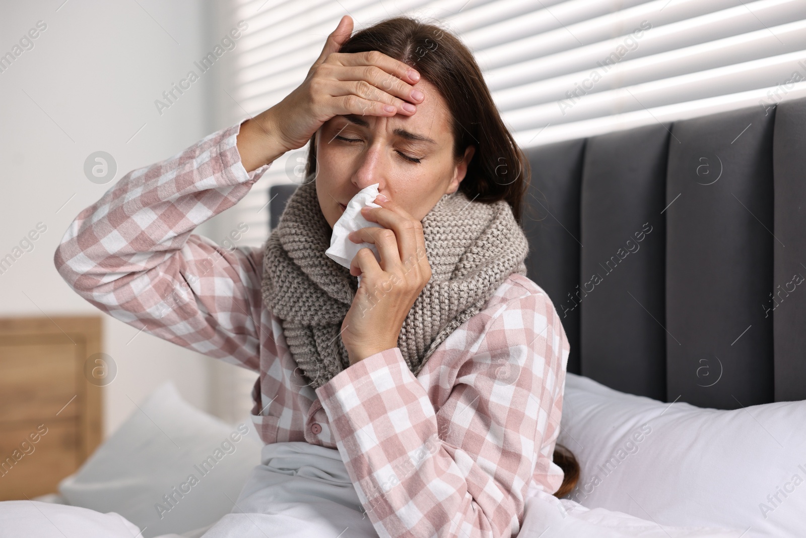 Photo of Sick woman with tissue in bed. Cold symptoms