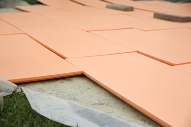 Photo of Under pool foam tiles on green grass in backyard