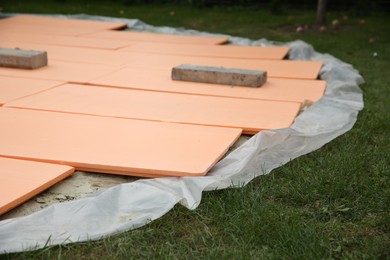 Under pool foam tiles on green grass in backyard