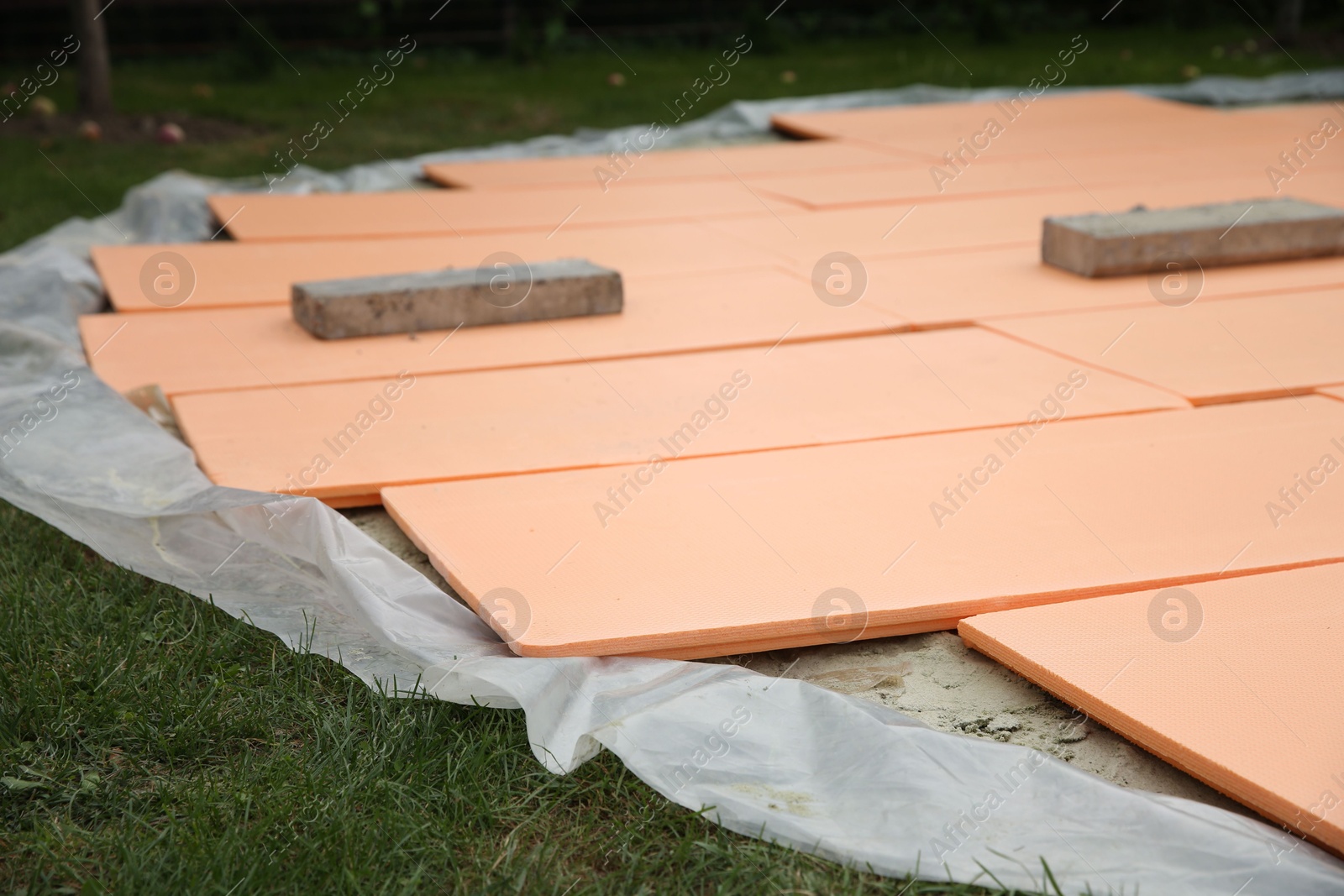 Photo of Under pool foam tiles on green grass in backyard