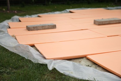 Under pool foam tiles on green grass in backyard