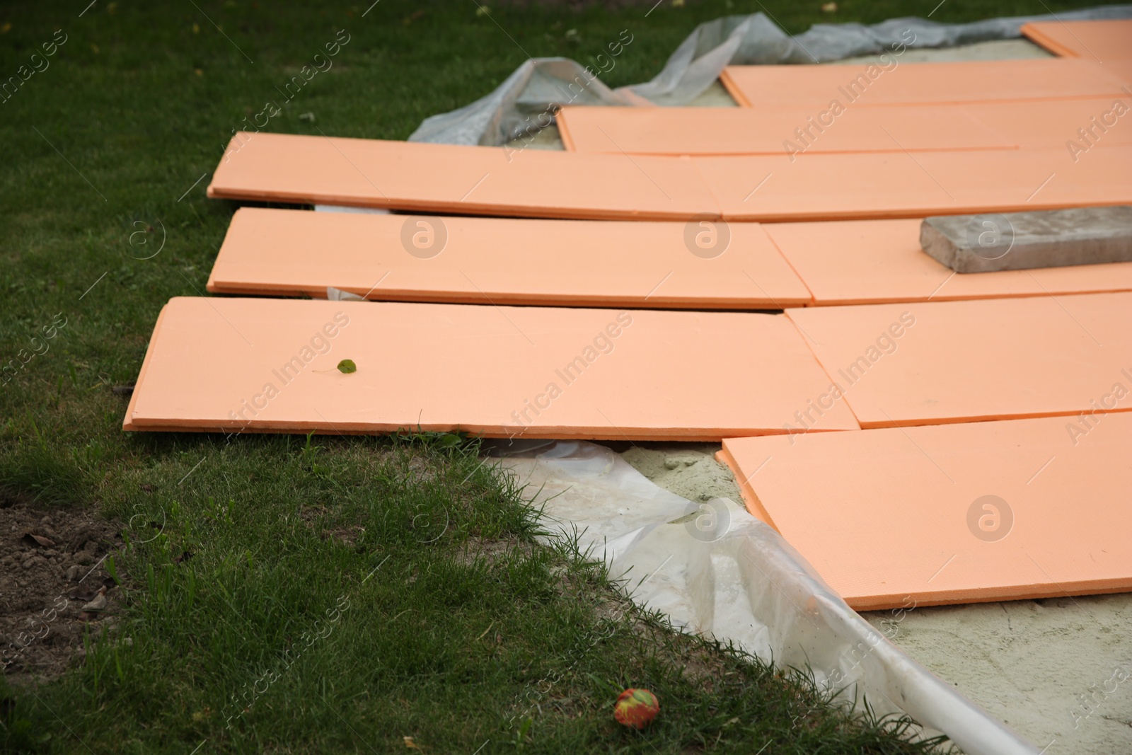 Photo of Under pool foam tiles on green grass in backyard