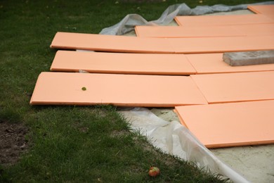 Photo of Under pool foam tiles on green grass in backyard