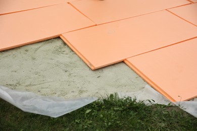 Under pool foam tiles on green grass in backyard