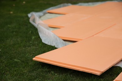 Photo of Under pool foam tiles on green grass in backyard