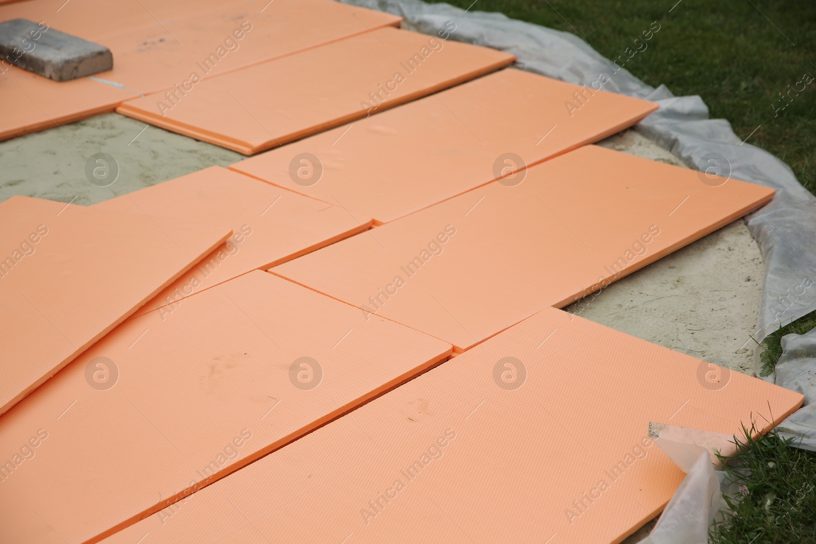 Photo of Under pool foam tiles on green grass in backyard