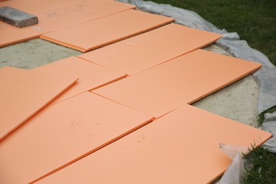 Under pool foam tiles on green grass in backyard