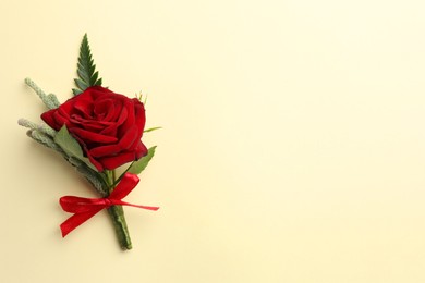 Small stylish boutonniere on beige background, top view. Space for text