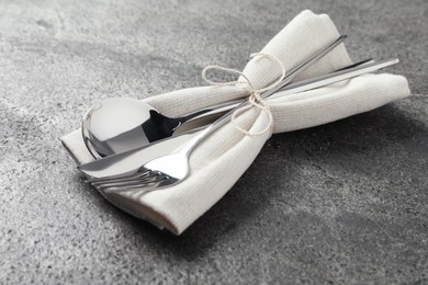 Photo of Stylish silver cutlery and napkin on grey table