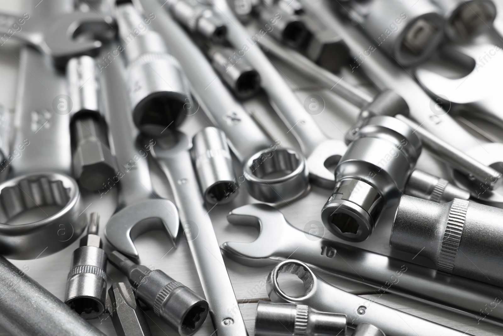 Photo of Auto mechanic's tools on white wooden table, closeup