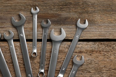 Many auto mechanic's tools on wooden table, flat lay