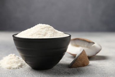 Photo of Coconut flour in bowl on light grey table, closeup