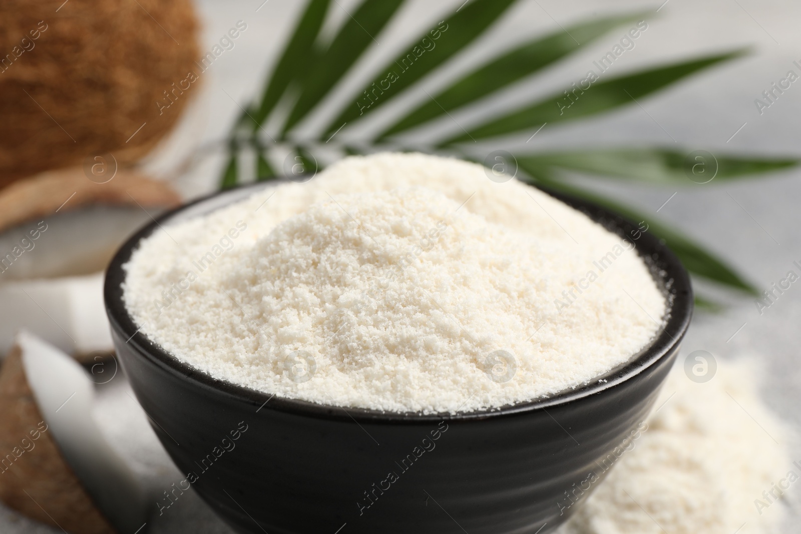 Photo of Coconut flour in bowl on table, closeup