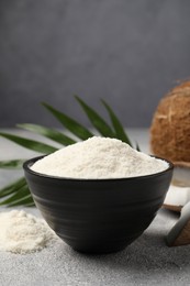 Coconut flour in bowl on light grey table, closeup