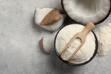 Photo of Coconut flour in bowl, scoop and fresh fruits on light grey table, flat lay. Space for text