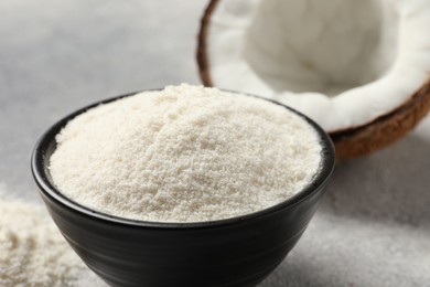 Photo of Coconut flour in bowl and fresh fruit on light grey table, closeup