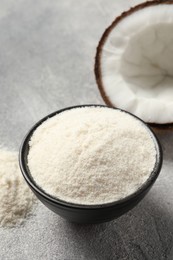 Photo of Coconut flour in bowl and fresh fruit on light grey table, closeup