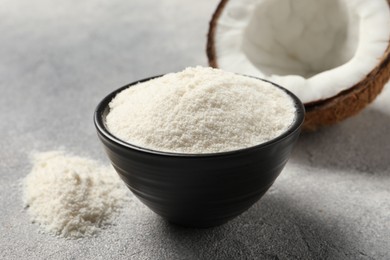 Photo of Coconut flour in bowl and fresh fruit on light grey table, closeup