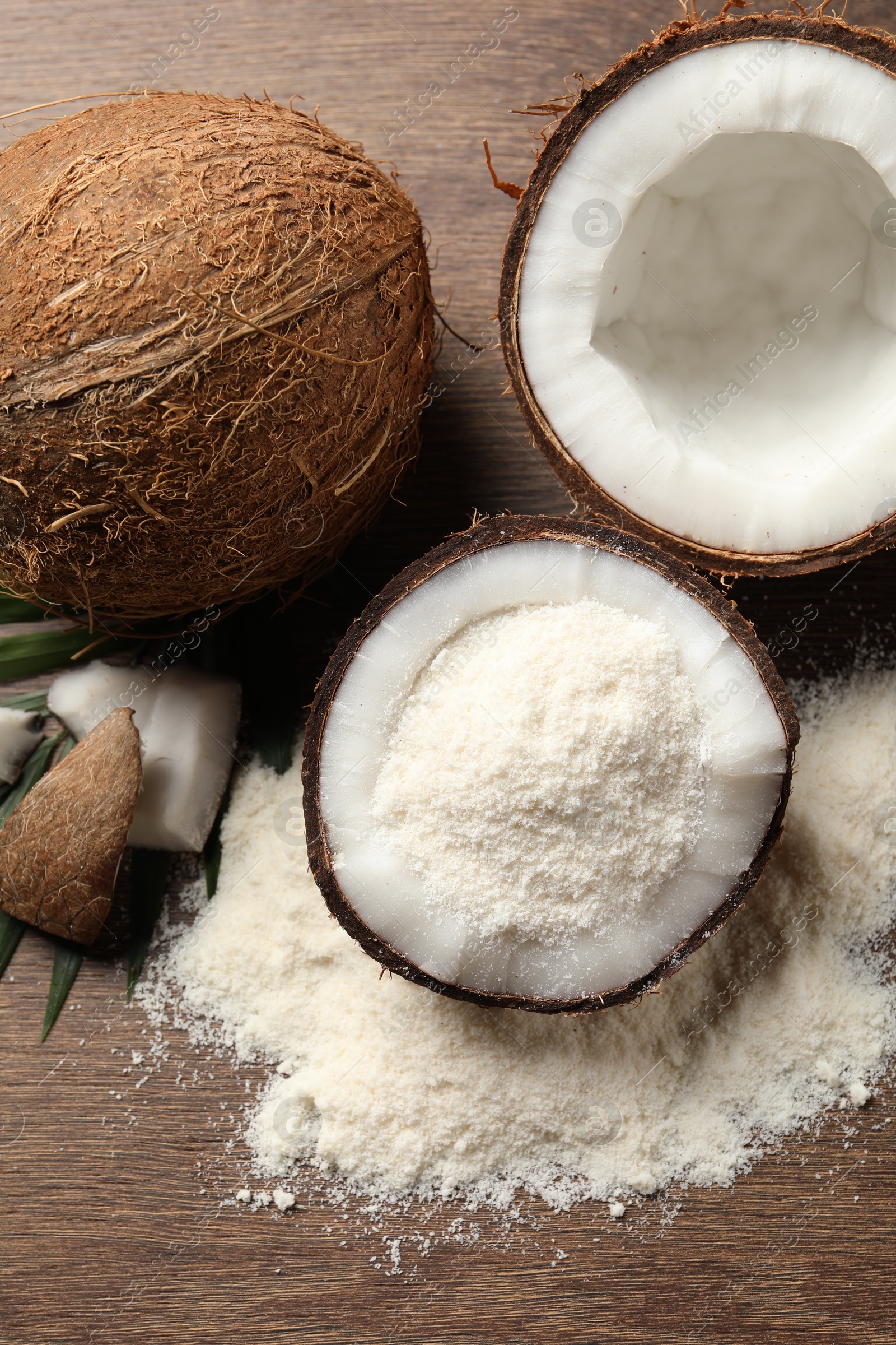 Photo of Coconut flour and fresh fruits on wooden table, flat lay