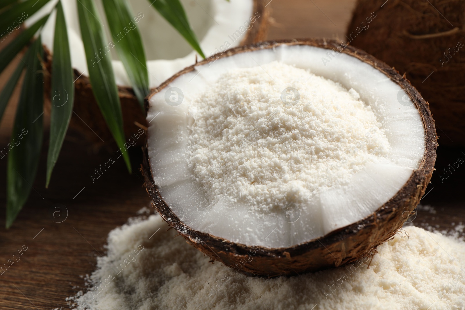 Photo of Coconut flour and fresh fruits on wooden table, closeup