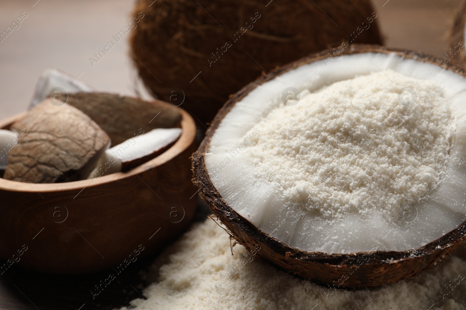 Photo of Coconut flour and fresh fruits on wooden table, closeup