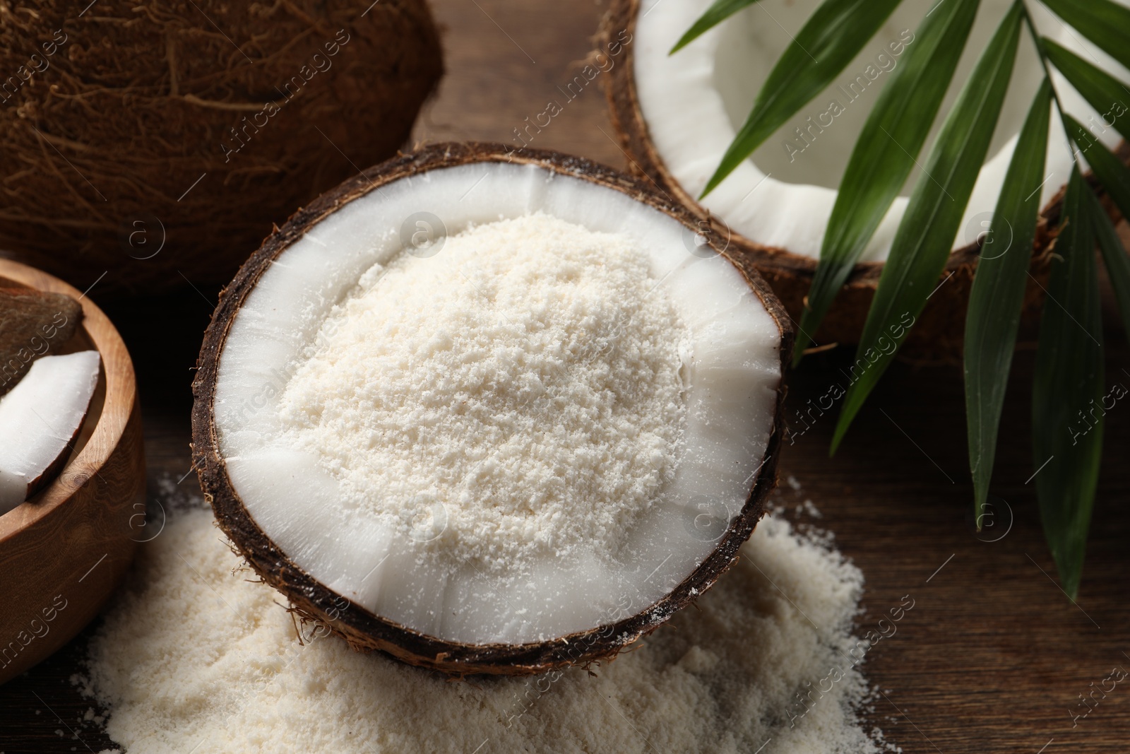 Photo of Coconut flour, fresh fruits and leaf on wooden table, closeup