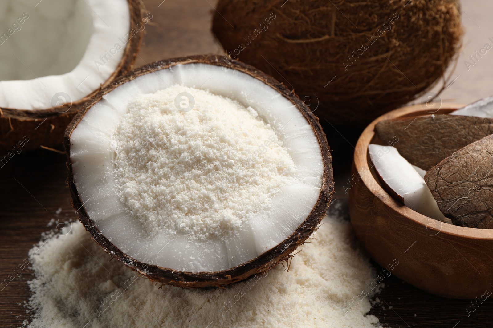 Photo of Coconut flour and fresh fruits on wooden table, closeup