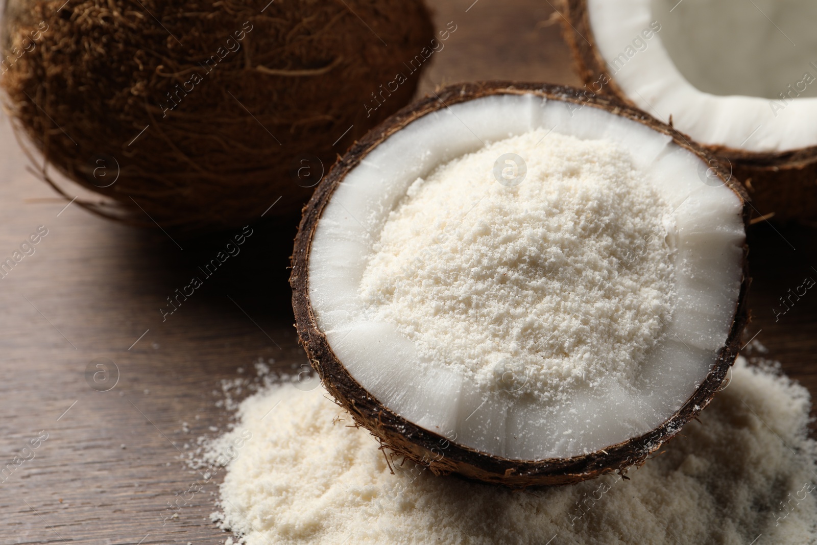 Photo of Coconut flour and fresh fruits on wooden table, closeup