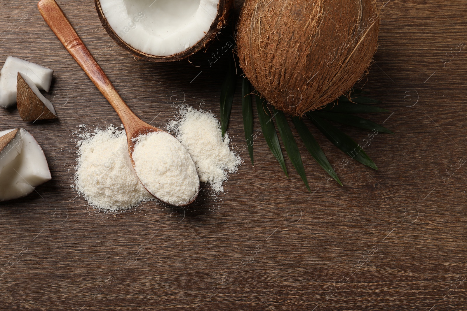 Photo of Coconut flour, fresh fruits and leaf on wooden table, flat lay. Space for text