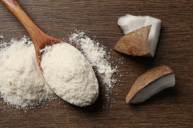 Photo of Coconut flour in spoon and fruit pieces on wooden table, flat lay