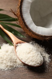 Photo of Coconut flour in spoon and fresh fruit on wooden table, closeup