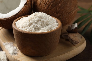 Photo of Coconut flour in bowl and fresh fruits on table, closeup