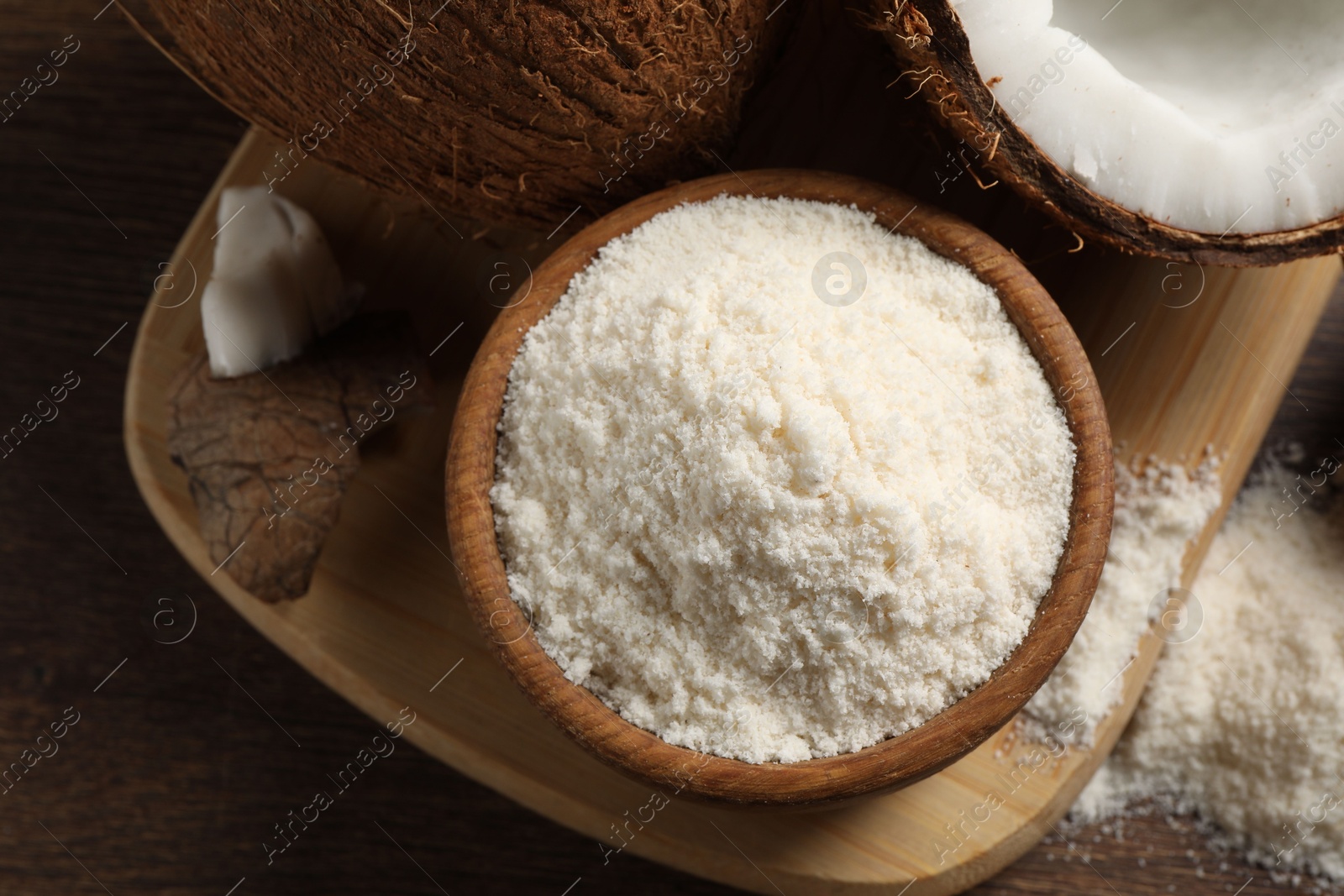 Photo of Coconut flour in bowl and fresh fruits on wooden table, flat lay