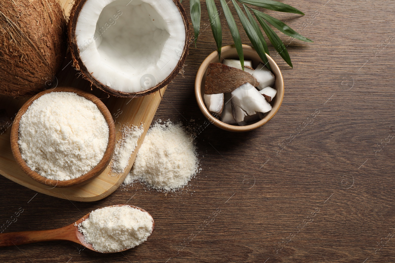 Photo of Coconut flour, fresh fruits and leaf on wooden table, flat lay. Space for text