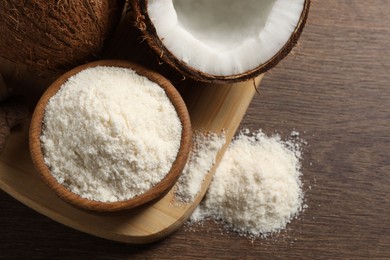 Photo of Organic coconut flour in bowl and fresh fruits on wooden table, flat lay