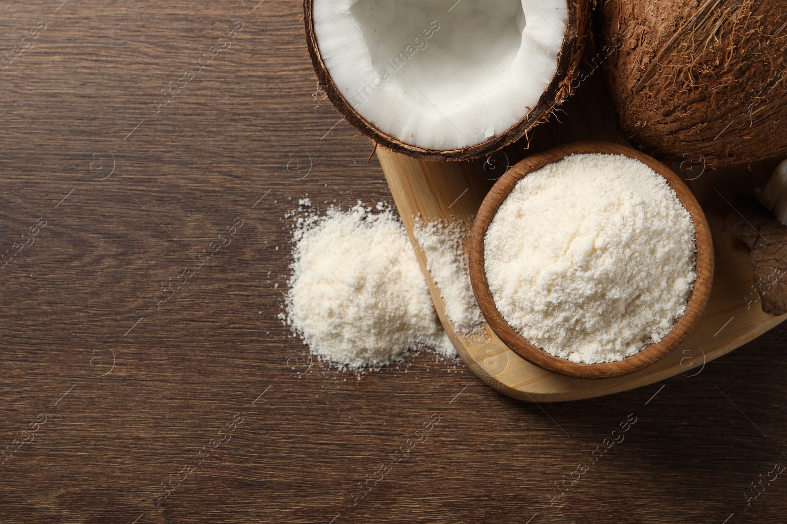 Photo of Organic coconut flour in bowl and fresh fruits on wooden table, flat lay. Space for text