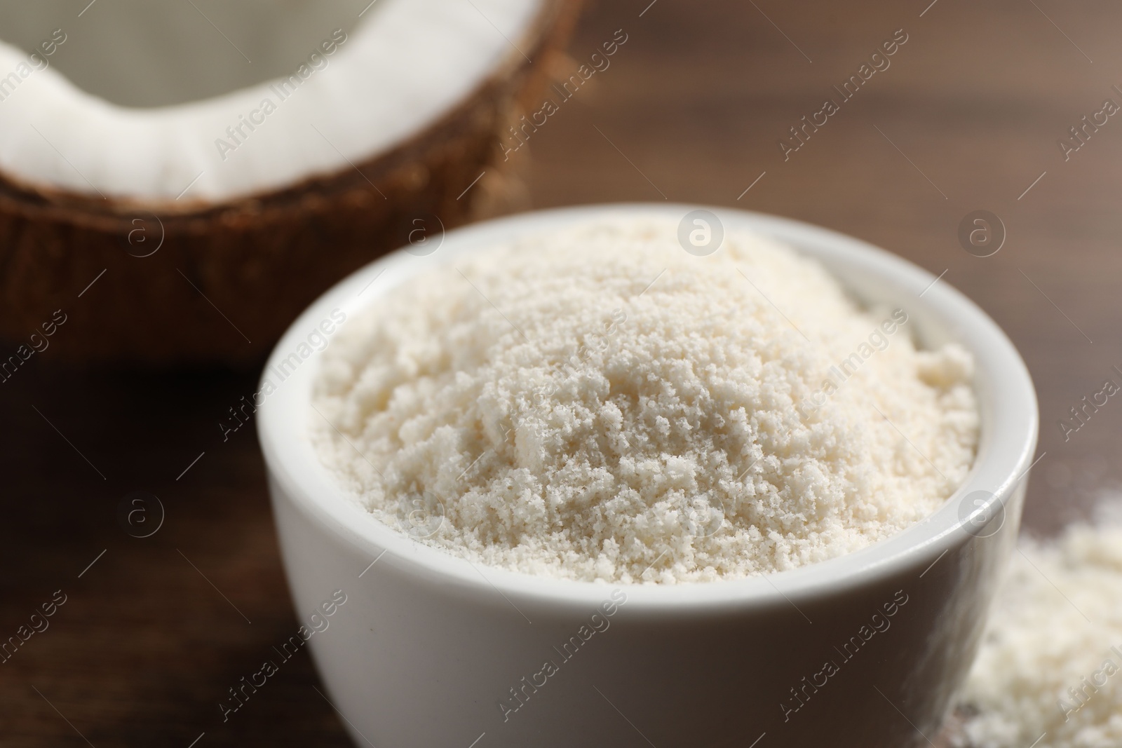 Photo of Organic coconut flour in bowl on table, closeup