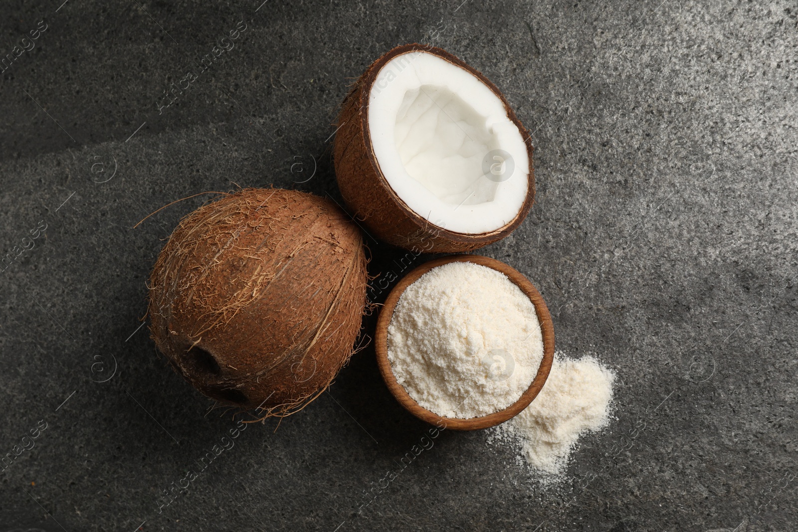 Photo of Organic coconut flour in bowl and fresh fruits on grey table, flat lay