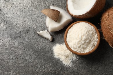 Photo of Organic coconut flour in bowl and fresh fruits on grey table, flat lay. Space for text