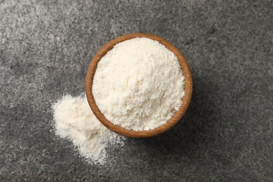 Photo of Organic coconut flour in bowl on grey table, top view