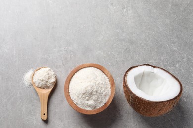 Photo of Organic coconut flour in bowl, spoon and fresh fruit on light grey table, flat lay. Space for text