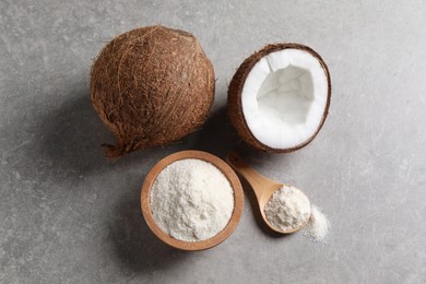 Photo of Organic coconut flour in bowl, spoon and fresh fruits on light grey table, flat lay