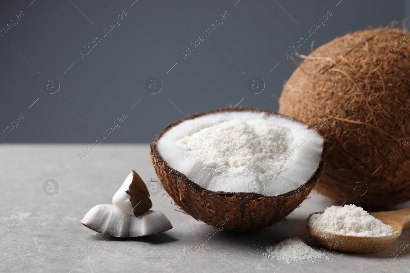 Photo of Organic coconut flour and fresh fruits on light grey table, closeup. Space for text