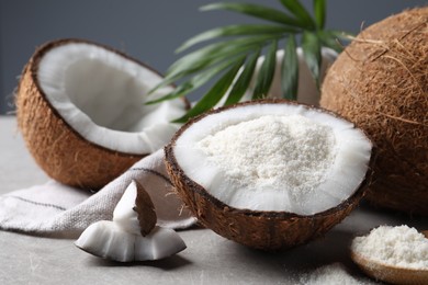 Photo of Organic coconut flour, fresh fruits and leaf on light grey table, closeup