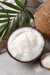 Photo of Organic coconut flour, fresh fruit and leaf on light grey table, closeup